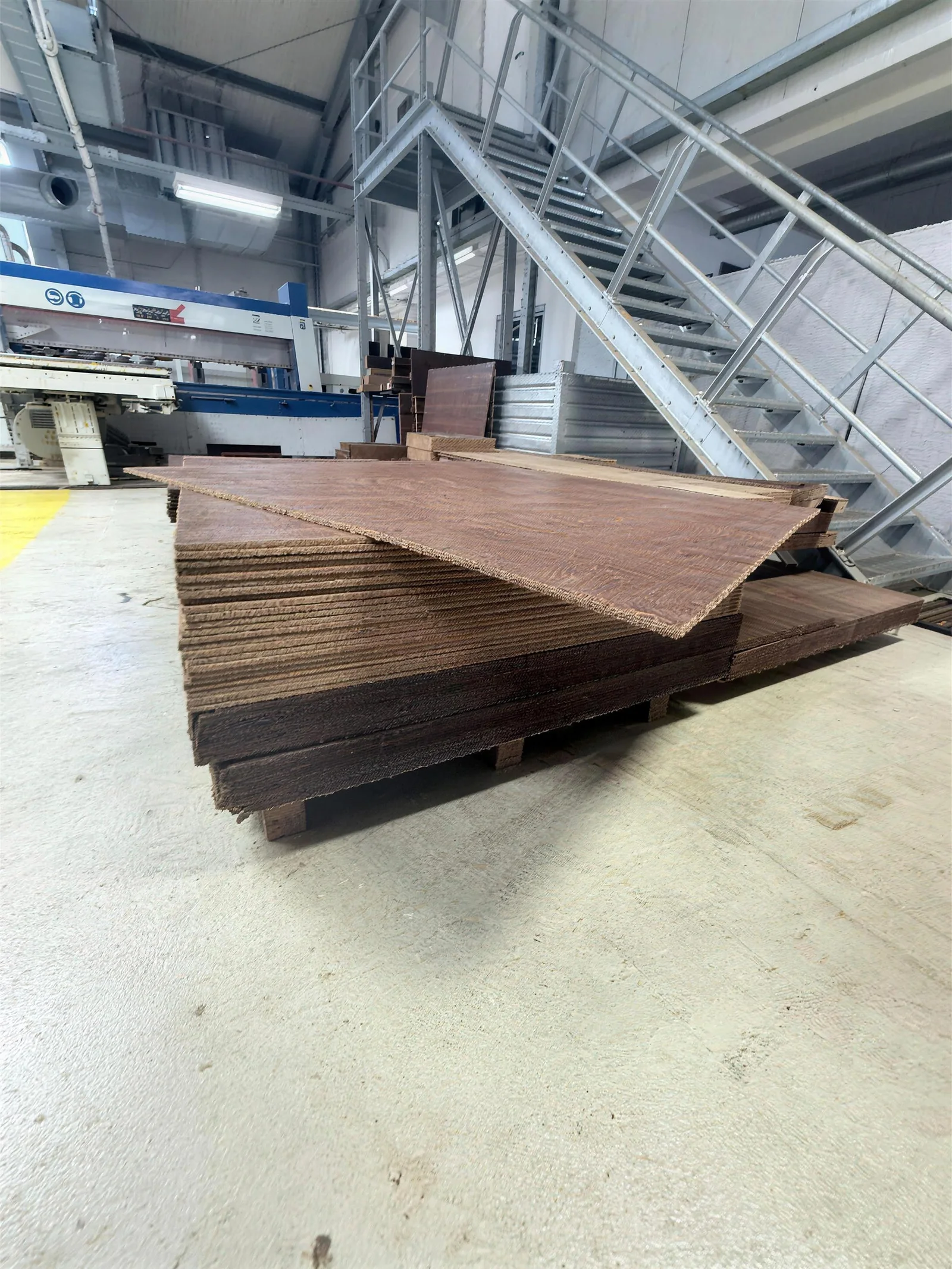 Stapel von Hardcork-Großformatplatten in der Produktion, im Hintergrund die CNC-Fräse
